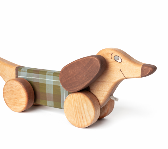 When organic wooden toy pull along dog is being pulled, he starts flapping his ears and swinging up and down with his front wheels. 